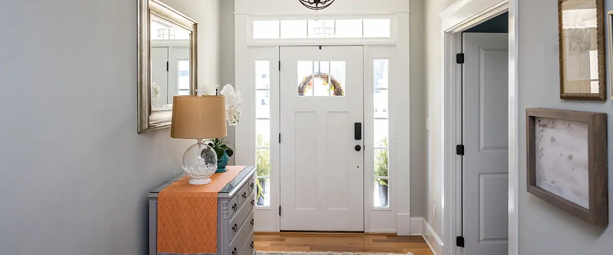 A well staged entryway facing the front door that's surrounded by windows and natural light.