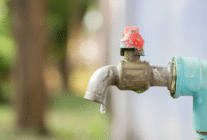 A dripping outdoor hose faucet.