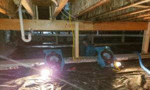 A photo of a crawlspace filled with piping, lights, and heaters.