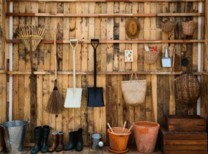 Hanging gardening tools in an outdoor shed.