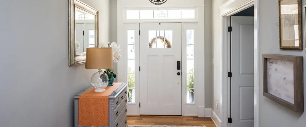 A well staged entryway facing the front door that's surrounded by windows and natural light.